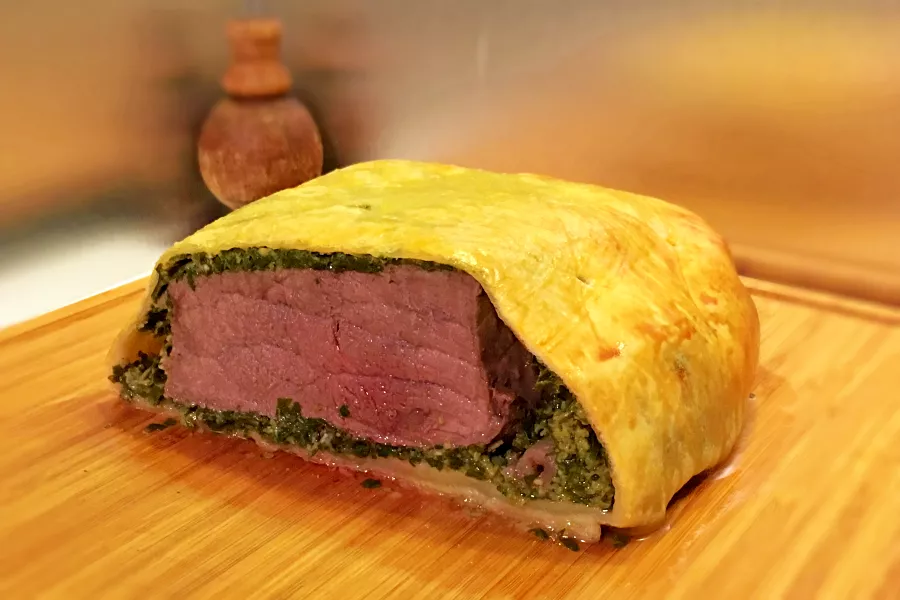 Rôti de boeuf en croute doré et croustillant, tranché avec garniture au persil