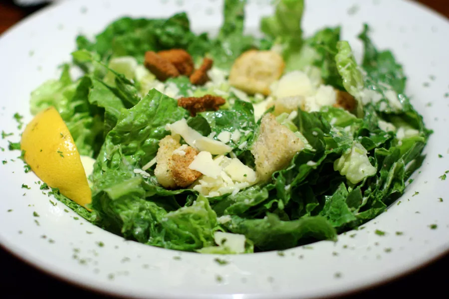 Salade Caesar maison avec laitue croquante, poulet grillé, croutons et parmesan râpé