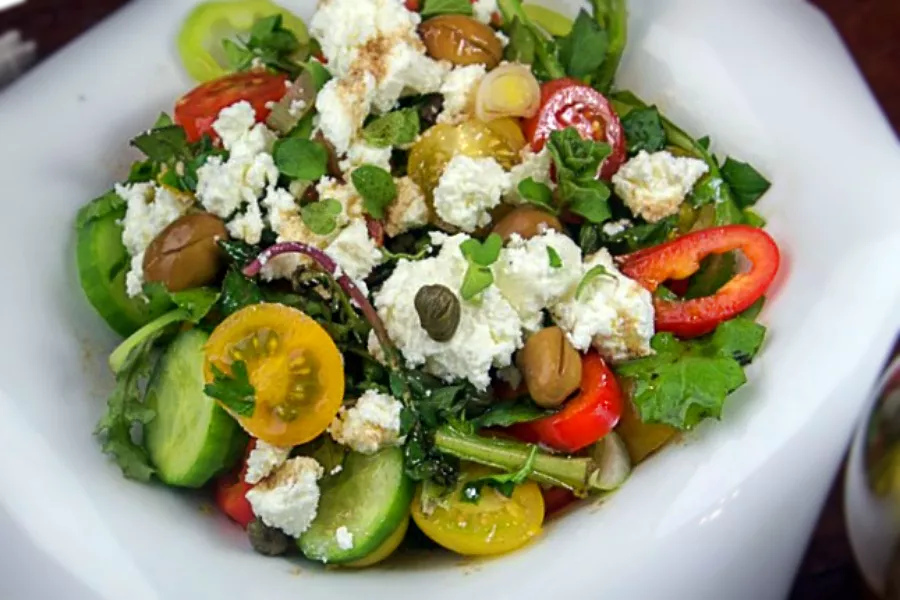 Salade grecque maison avec tomates, anchois, oignons rouges, olives et feta