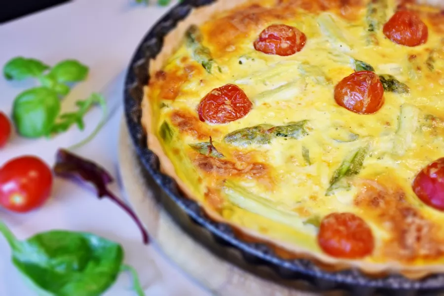 Tarte aux asperges et cantal dorée garnie d'asperges fraîches et fromage fondant