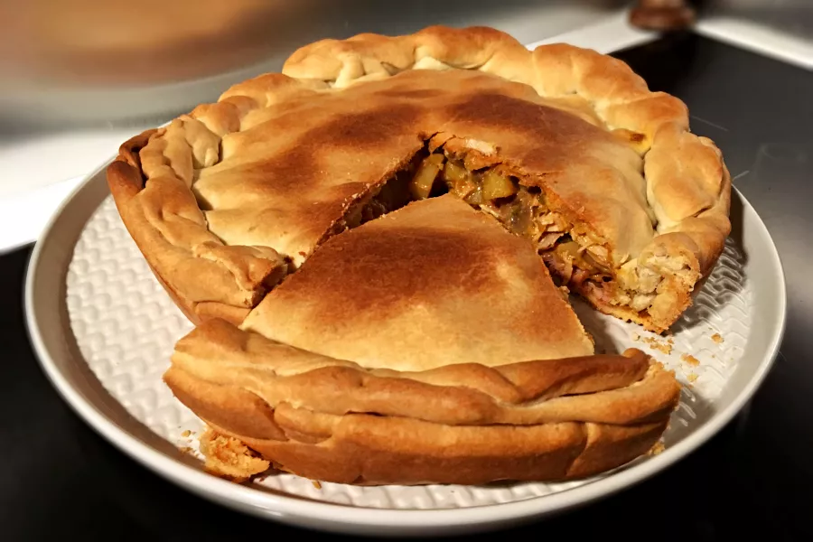 Tourte au poulet dorée avec zestes de citron, garnie de pâte brisée croustillante